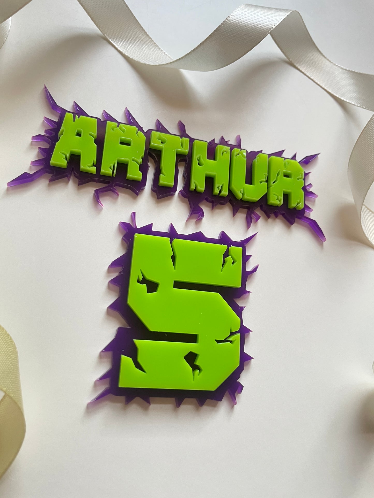 Green and purple acrylic name and age charm. Superhero themed.