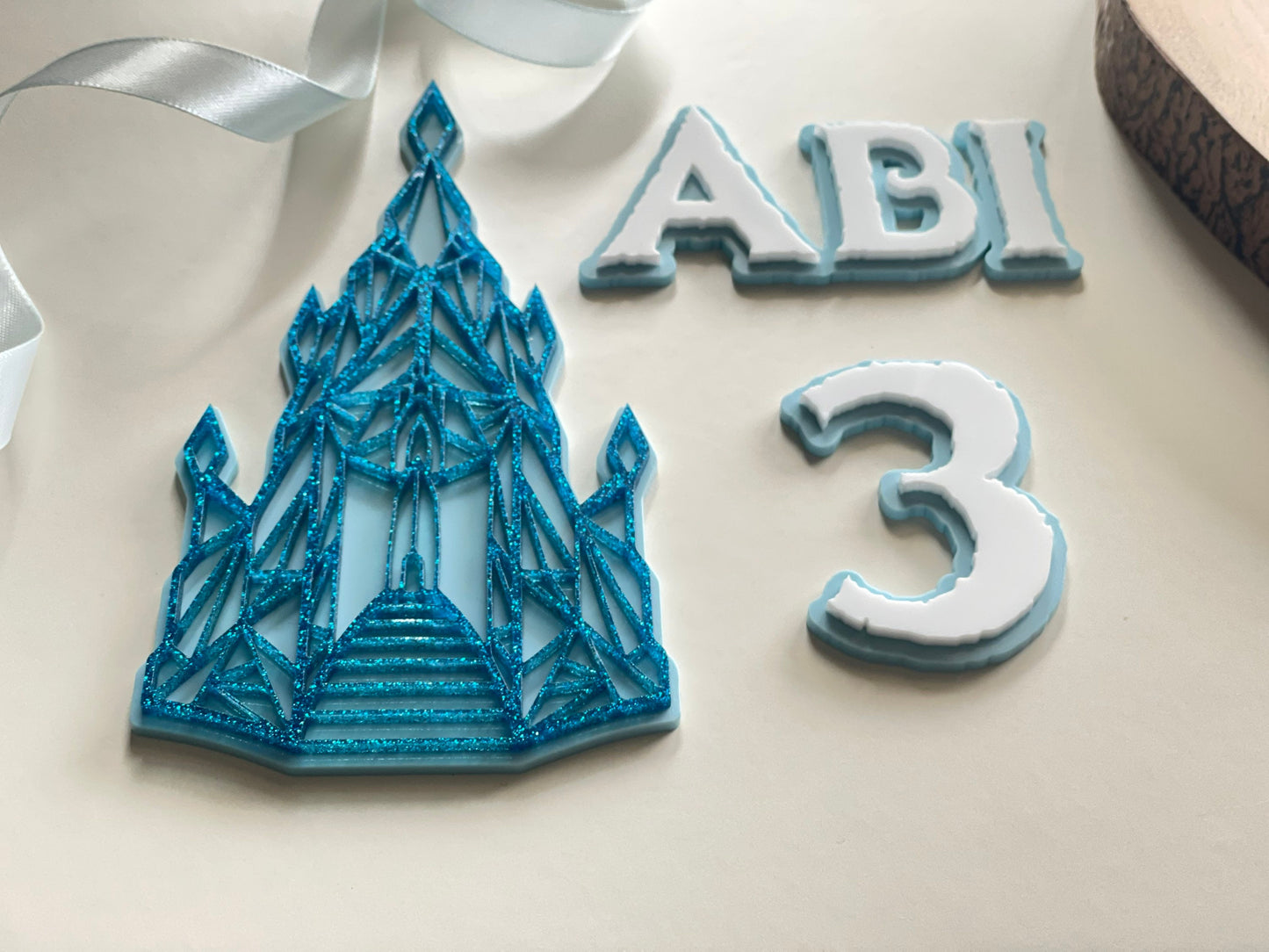 Name and age charm. Acrylic glitter Ice castle. Frozen / winter themed cake decorations.