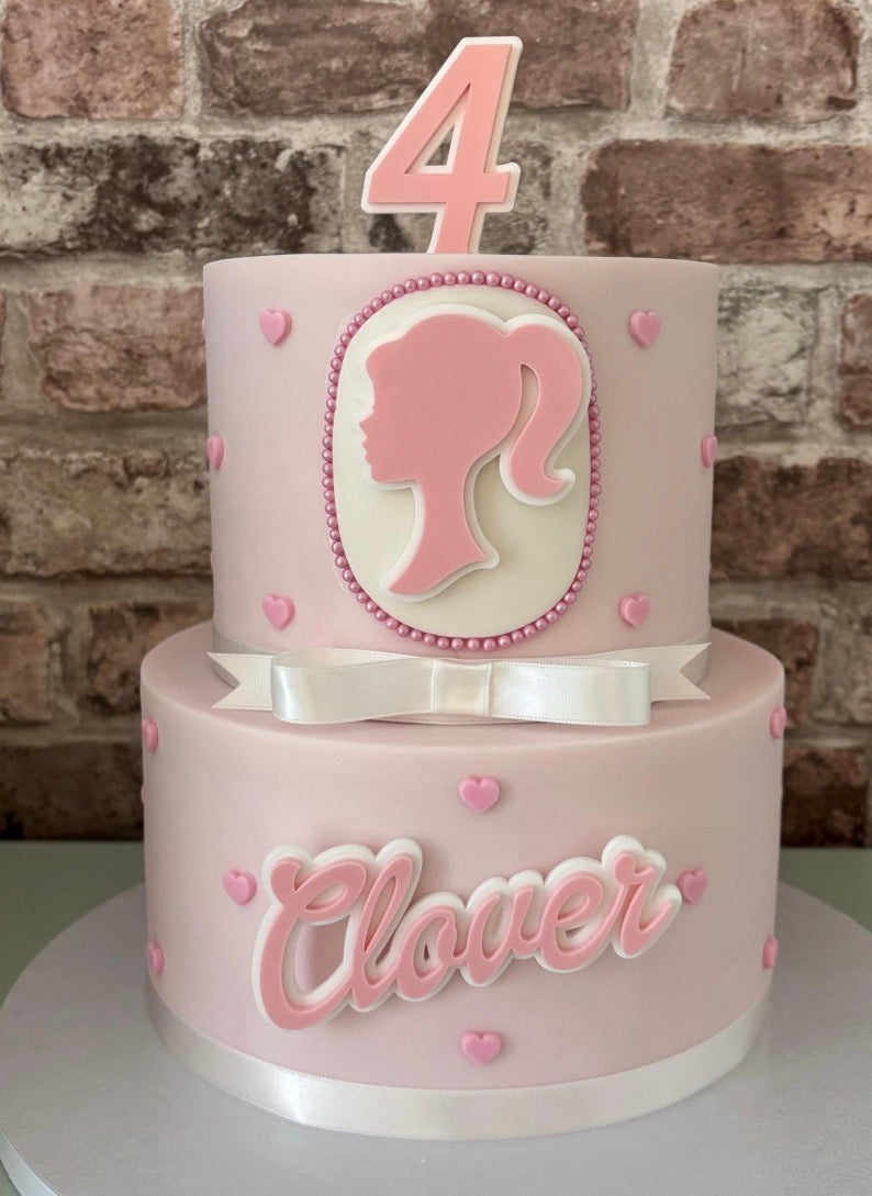 Doll themed pink acrylic cake charms.