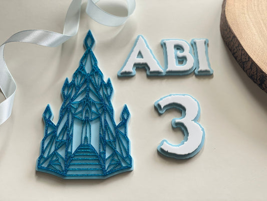 Name and age charm. Acrylic glitter Ice castle. Frozen / winter themed cake decorations.